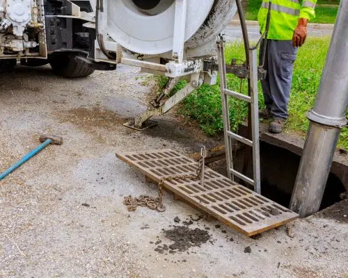 Pump truck hose setup beside an open underground access pit — Si View Septic Pumping in North Bend